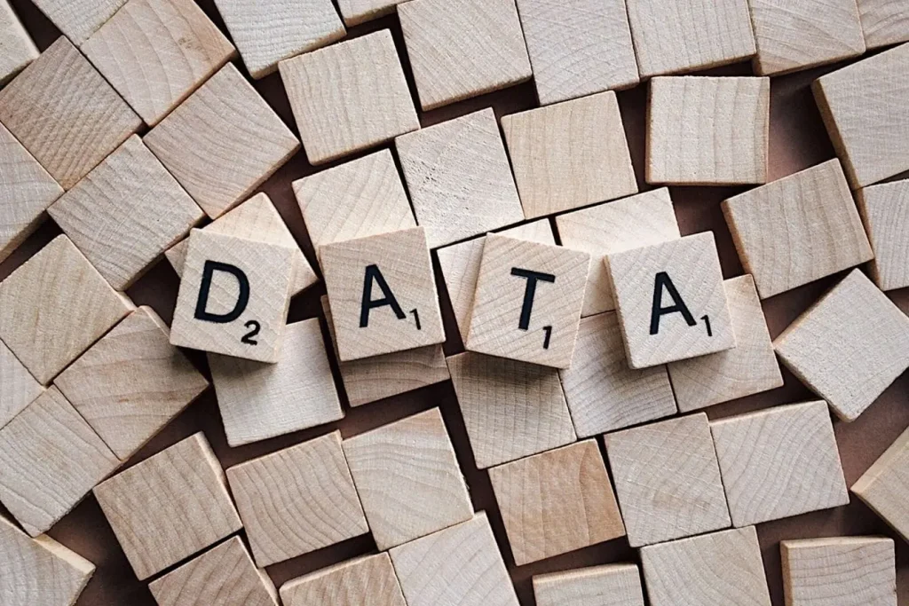 Tuiles en bois disposées serrées avec lettres formant DATA, image illustrant la puissance du big data construit à partir d’éléments simples.