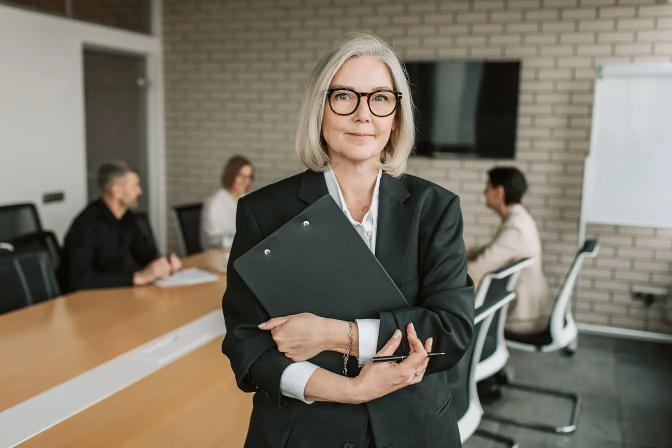 Dirigeant en costume tient dossier noir, image illustrant la réflexion sur le choix entre EI et EURL pour créer une entreprise.