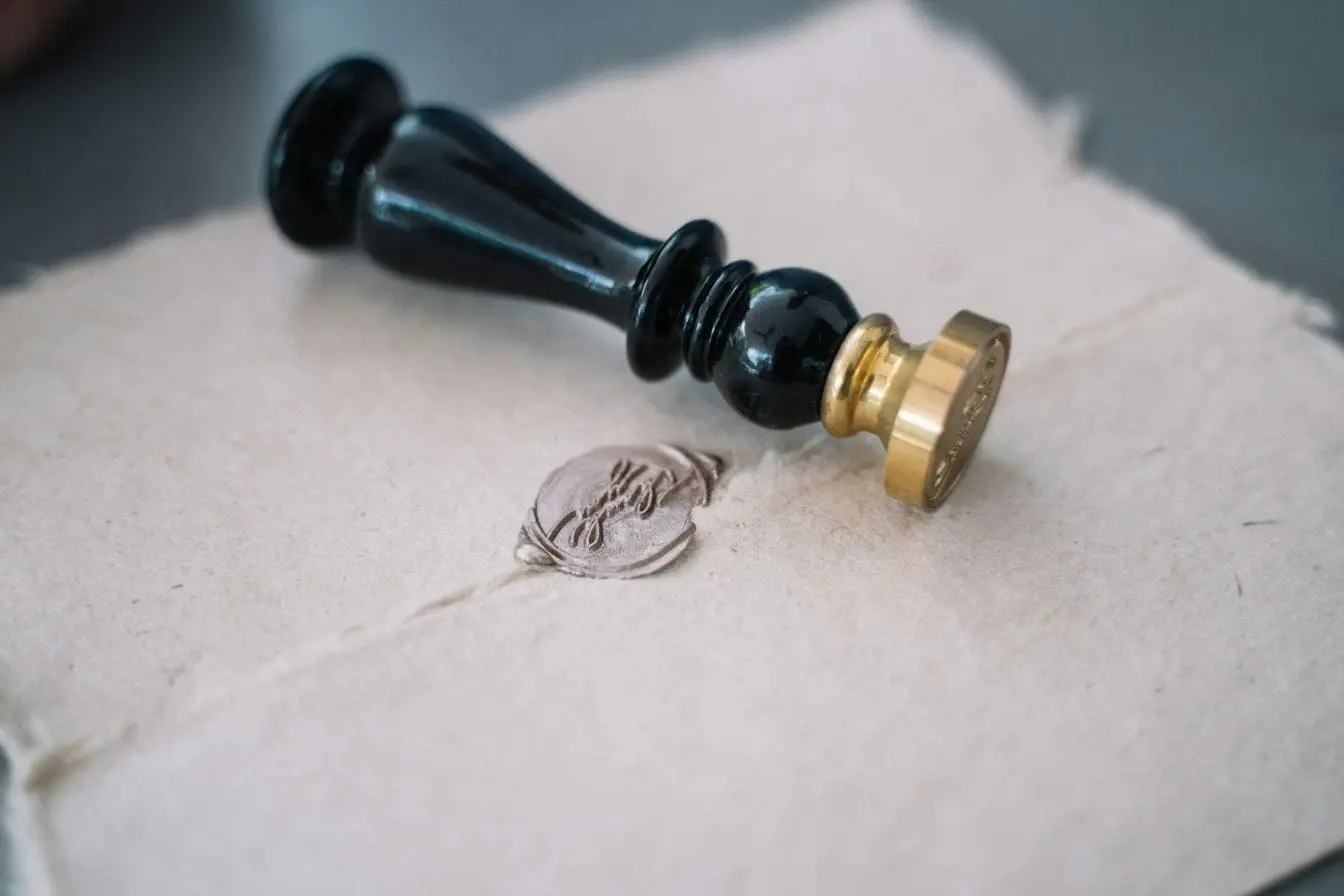 Tampon de cire noire posé sur parchemin, image illustrant la formalité juridique du dépôt de brevet en France.