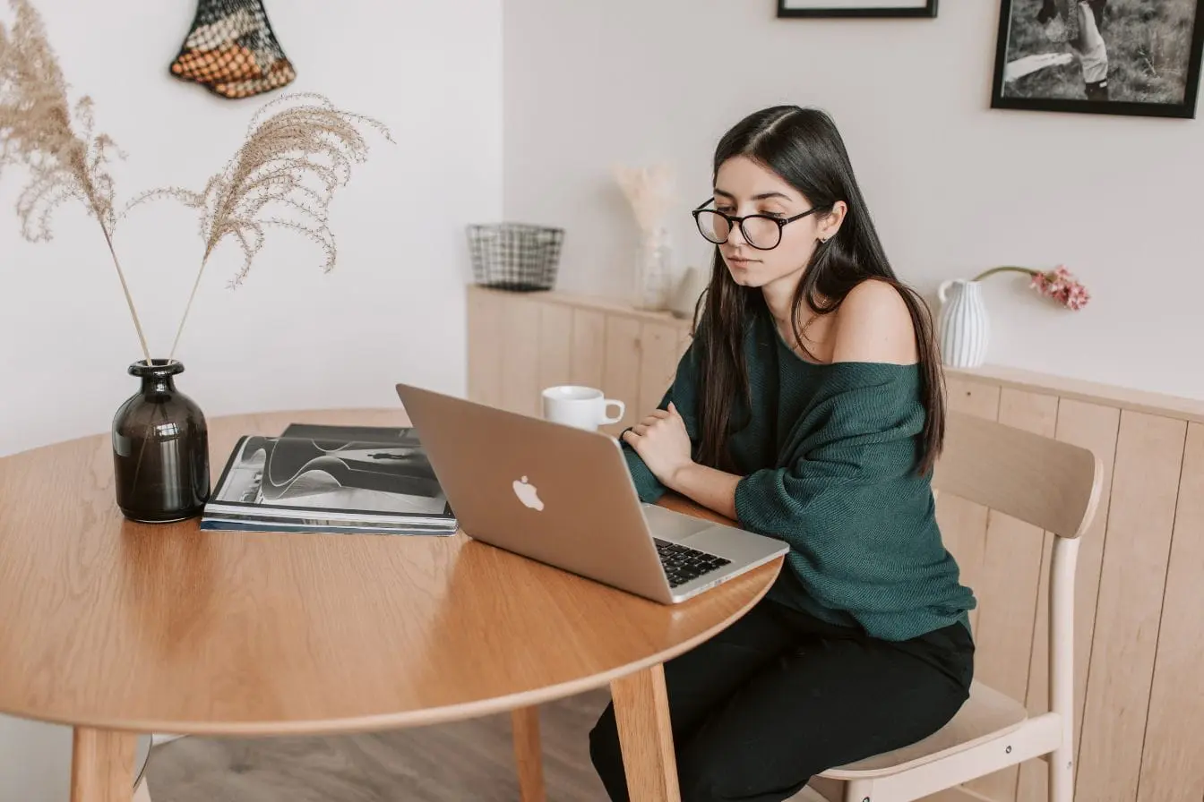 automatisation de la comptabilité Personne travaille sur ordinateur portable avec tasse de café, image illustrant l’automatisation de la comptabilité en freelance pour gagner du temps.
