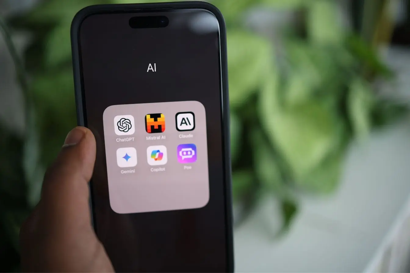 dossier IA Main tenant un smartphone affichant dossier IA avec applis, image qui illustre l’usage de l’IA générative pour développer son business.