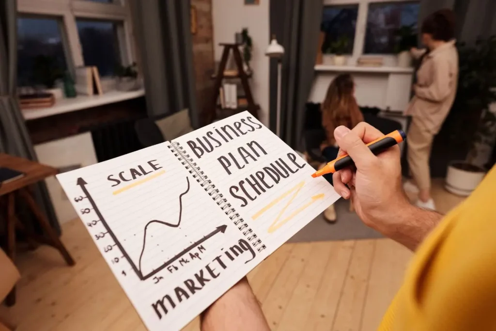Carnet ouvert avec notes manuscrites et graphique, image illustrant la préparation d’un business plan.