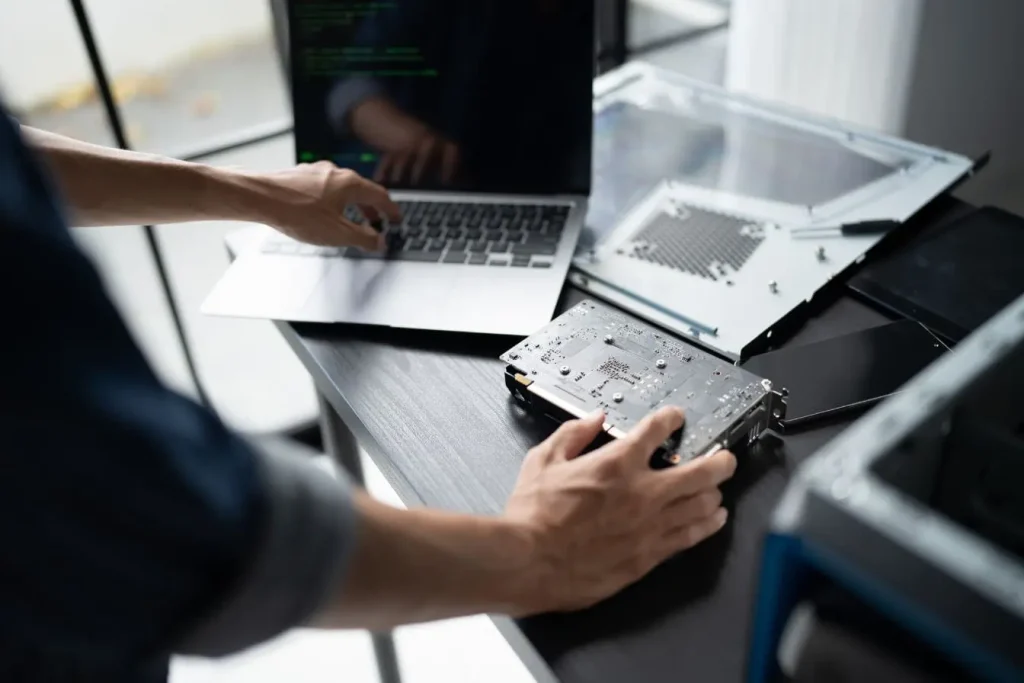 Personne travaillant sur un laptop avec écran de code vert, image qui illustre la protection d’un site web contre les cyberattaques.