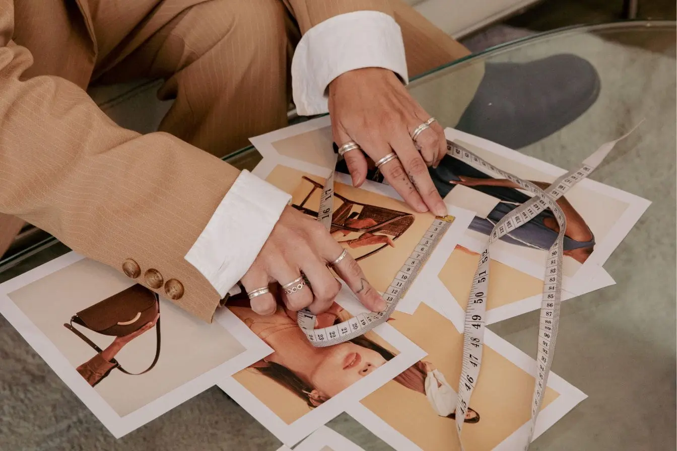 Création d’un moodboard Création d’un moodboard, photos de mode et accessoires disposés sur table en verre avec ruban de mesure pour inspiration créative.