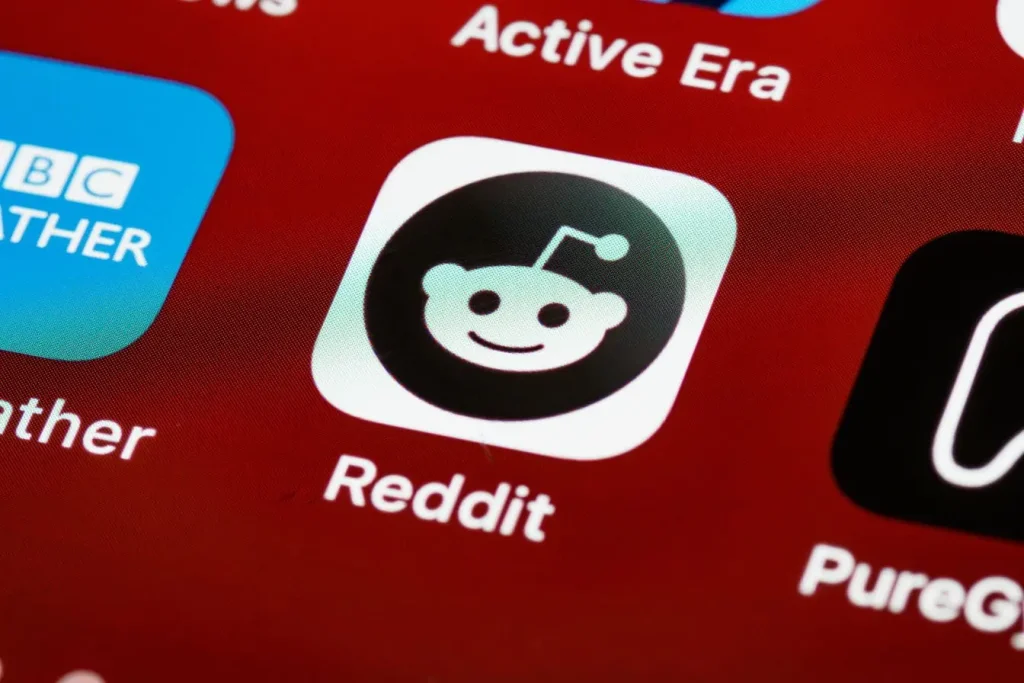 Gros plan sur écran de smartphone affichant l’icône Reddit, image qui illustre l’univers digital et l’importance du marketing sur Reddit.