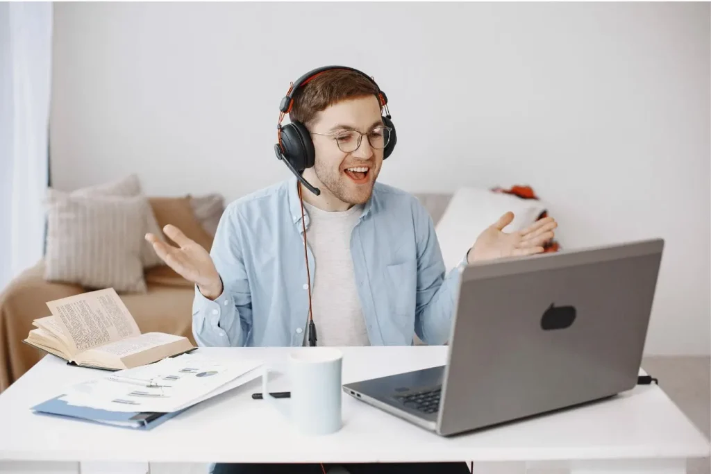 Personne portant casque micro devant laptop en visioconférence, image qui illustre la création d’une communauté en ligne active et connectée.