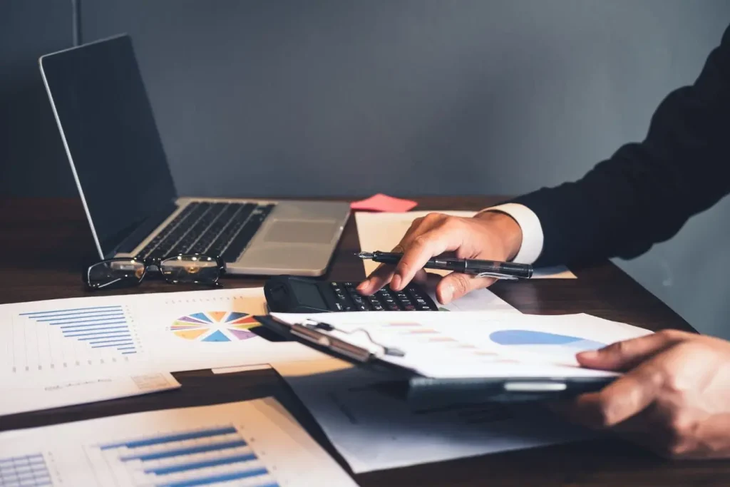 Bureau avec laptop, calculatrice et documents imprimés, reflet de l’approche analytique d’un audit de marque.
