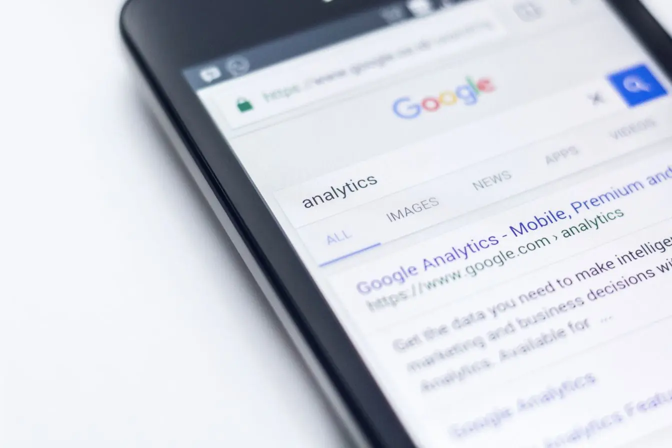 Écran de smartphone affichant recherche Google sur analytics, reflet des critères E-E-A-T de Google pour fiabilité et expertise.
