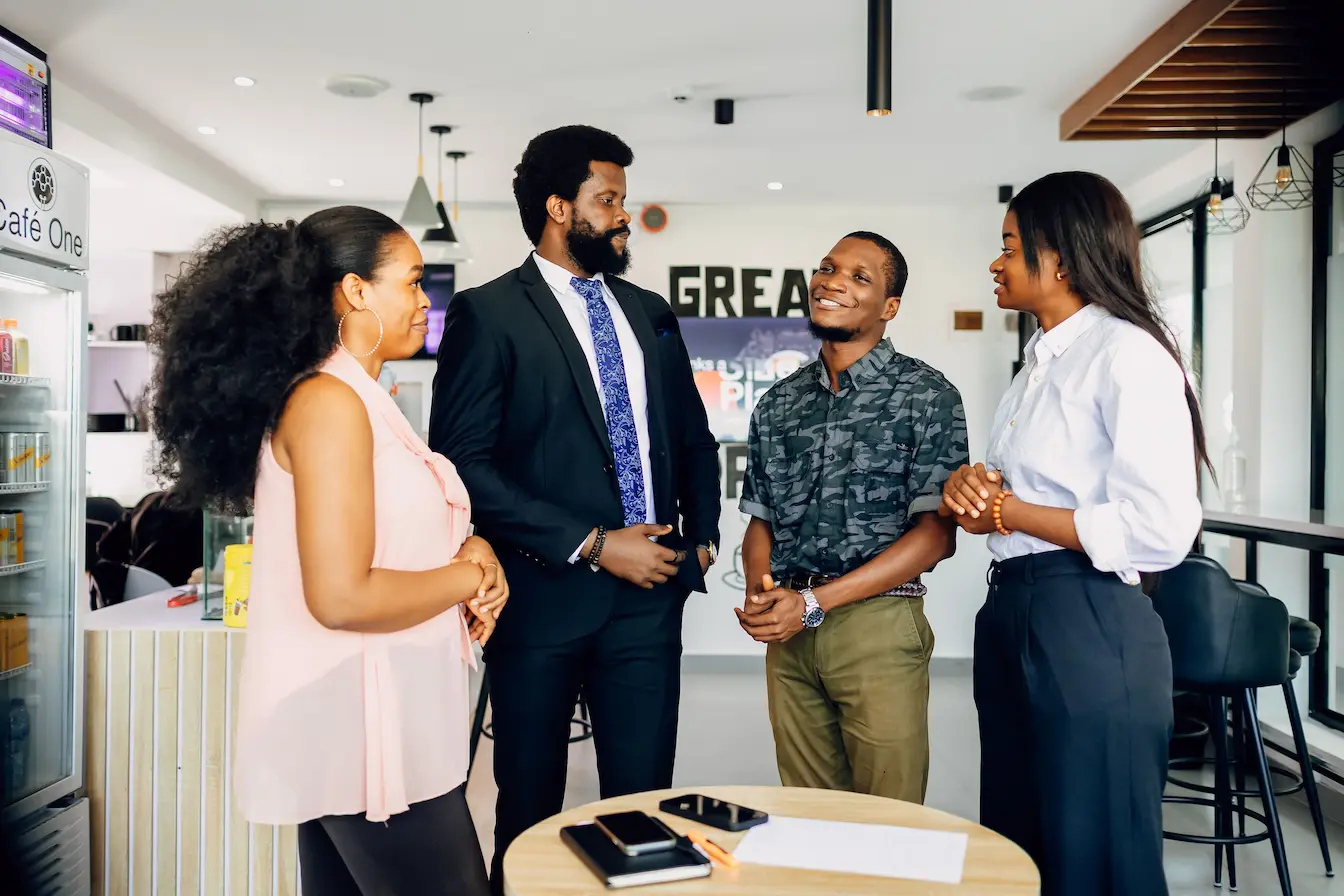 Business Angel Groupe de personnes discutant autour d’une table dans un café moderne, image qui illustre Business Angel vs Capital‑risqueur et leurs différences.
