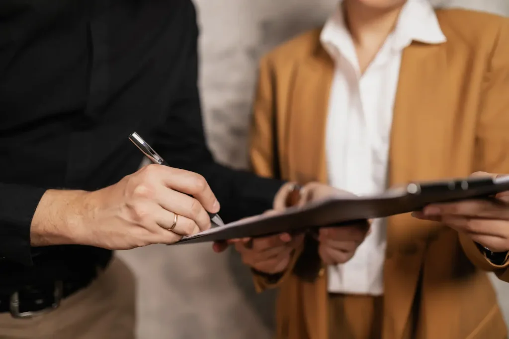 Signature d’un document entre deux collègues, illustration du pacte d’actionnaires et des clauses essentielles à intégrer absolument.