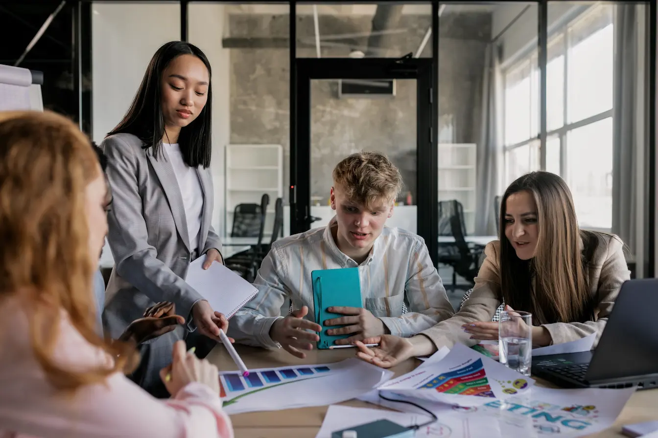 marketing expérientiel Groupe de collègues réunis autour d’une table avec échantillons colorés, image qui illustre le marketing expérientiel.