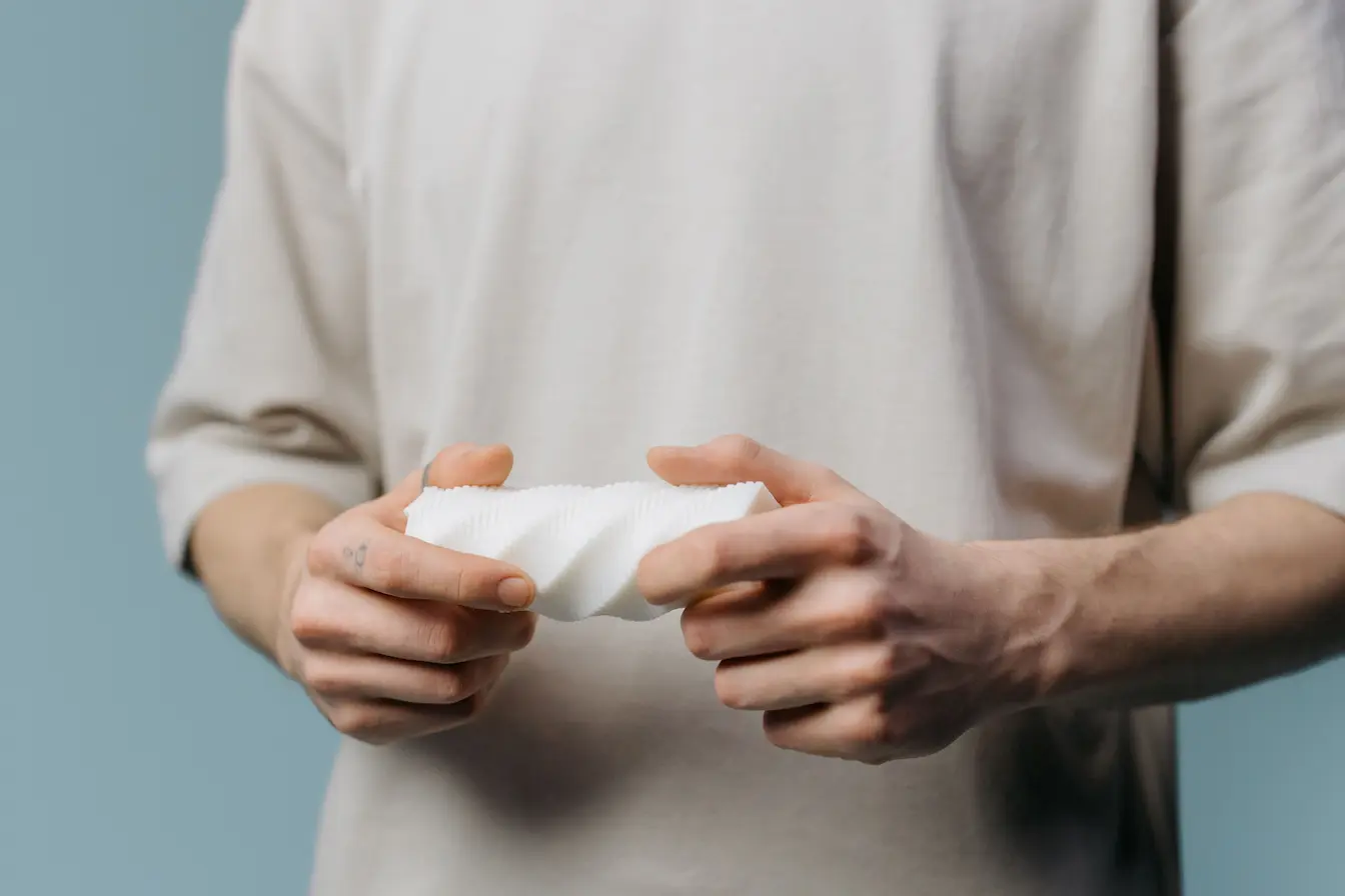 Personne tenant un objet blanc texturé, image qui illustre le marketing sensoriel et l’importance du toucher dans l’expérience client.