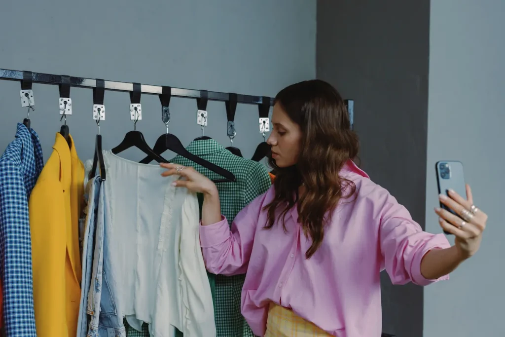 Personne prenant en photo des vêtements sur portants, image d’un marketing d’influence et micro‑influenceurs qui partagent leur stratégie pas à pas.