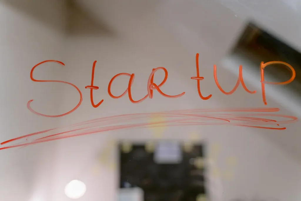 Mot startup écrit en rouge sur surface transparente, symbole du financement Love Money pour soutenir une jeune entreprise.