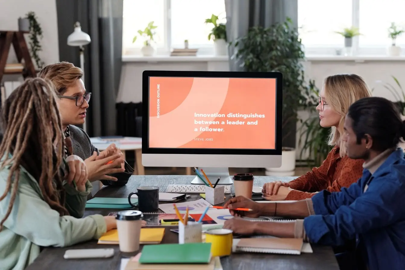 Une équipe attentive suit une session d'onboarding client SaaS sur l'écran d'un ordinateur de bureau.