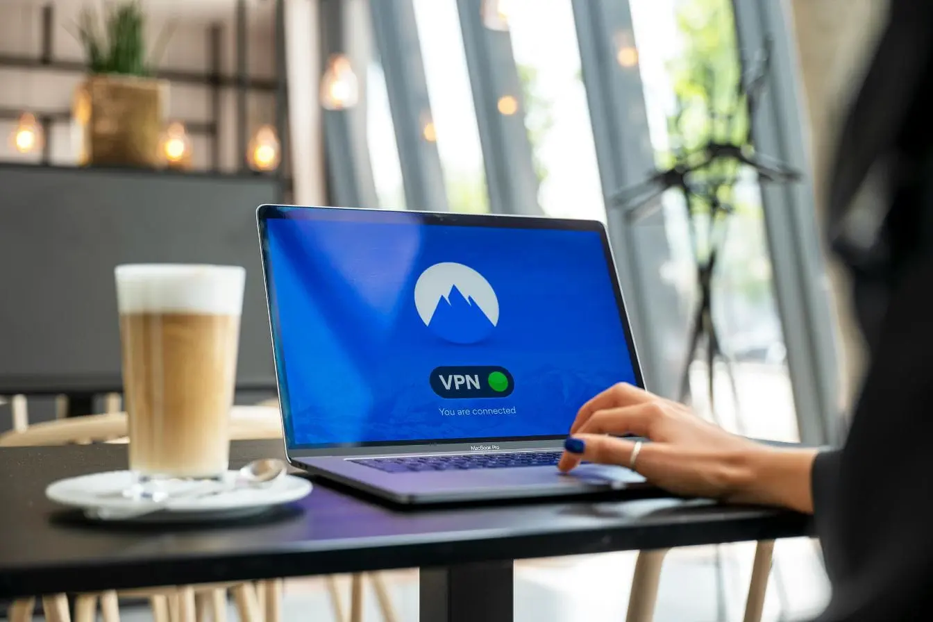 VPN Ordinateur portable affichant connexion VPN sécurisée dans café moderne, symbole des pratiques de cybersécurité en entreprise.