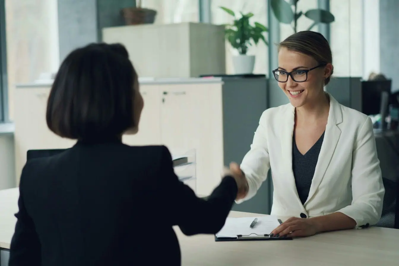 cycle de vente B2B Une poignée de main franche entre deux professionnelles scelle un accord commercial en B2B.