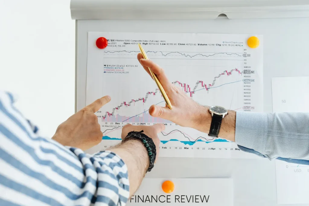 Deux personnes analysant graphiques financiers sur tableau blanc, symbole de la planification nécessaire pour installer un auvent au-dessus d’une terrasse.