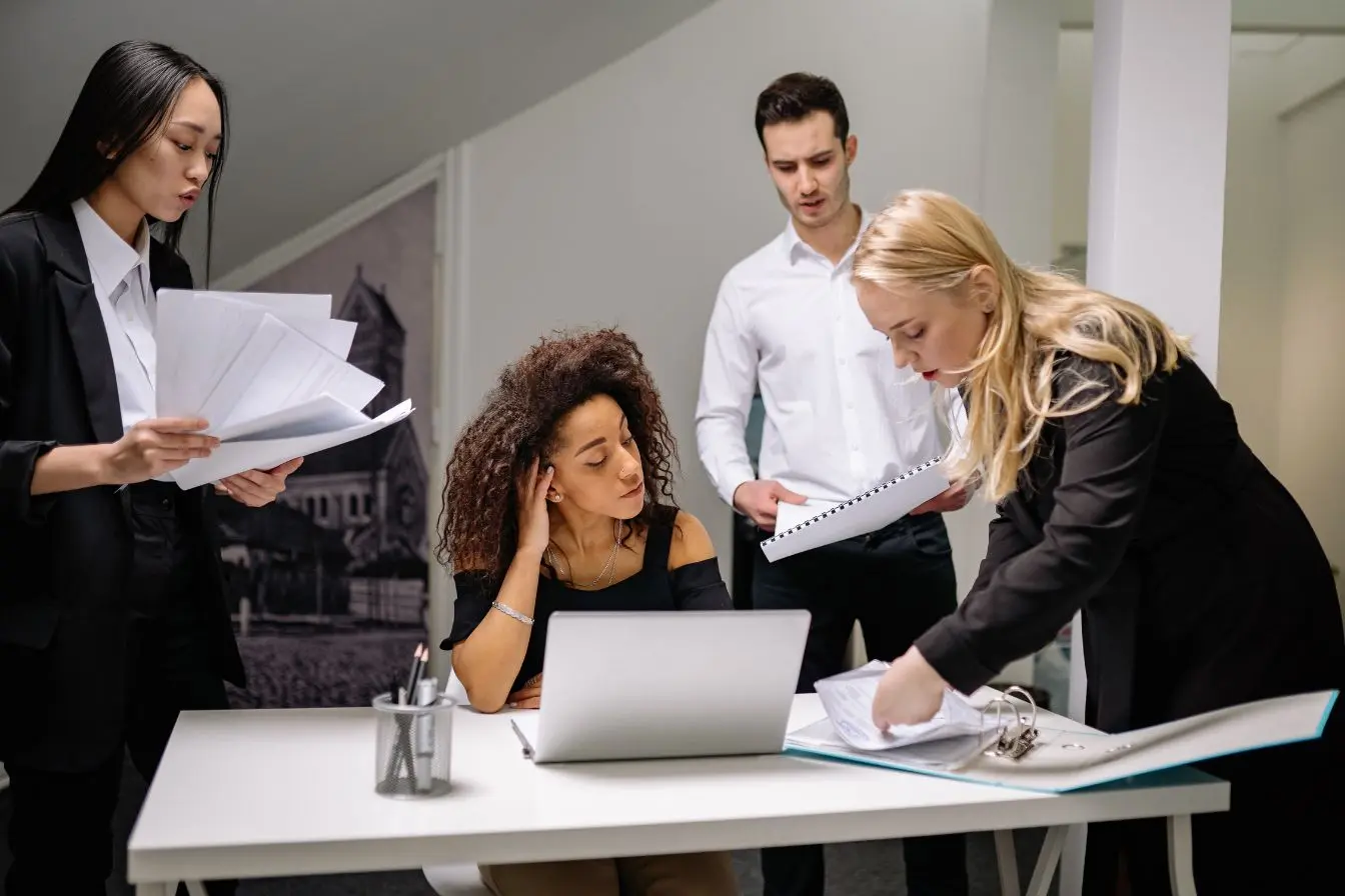 Une équipe de collaborateurs concentrée autour d'un bureau, analysant des documents pour illustrer la qualification des prospects grâce au lead scoring.