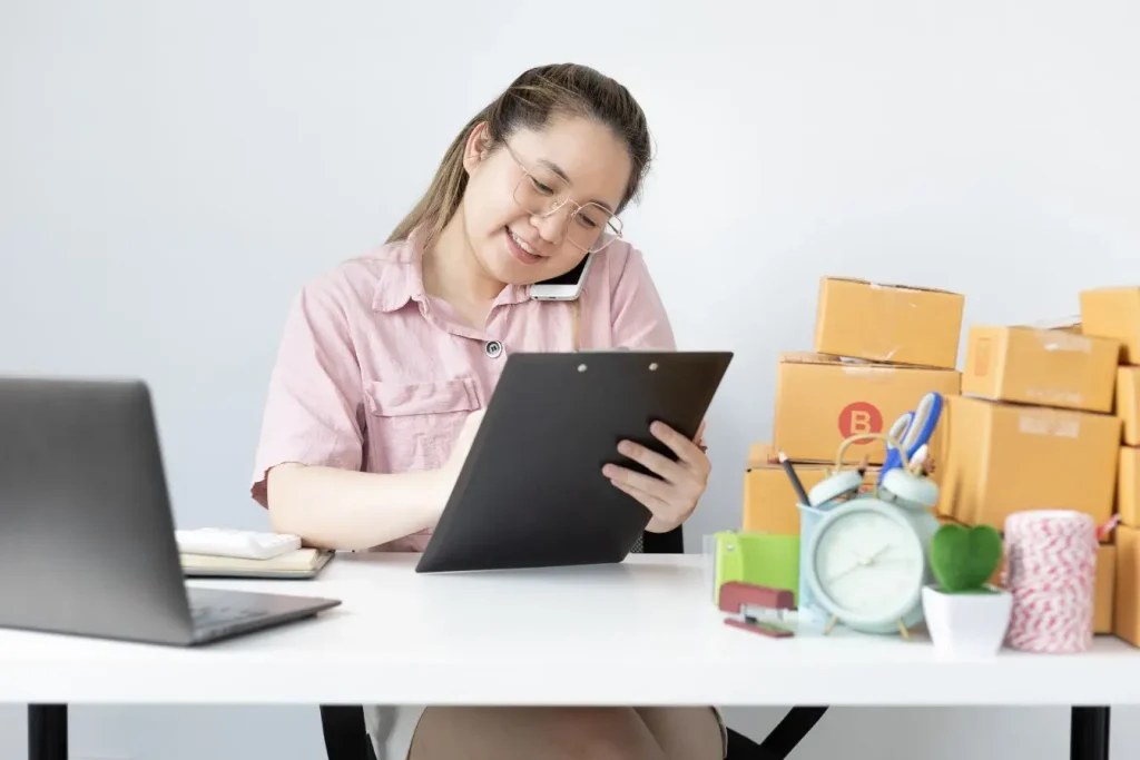 Professionnel échangeant avec un client par téléphone tout en consultant un dossier, illustrant la méthode SPIN Selling fondée sur l’écoute des besoins