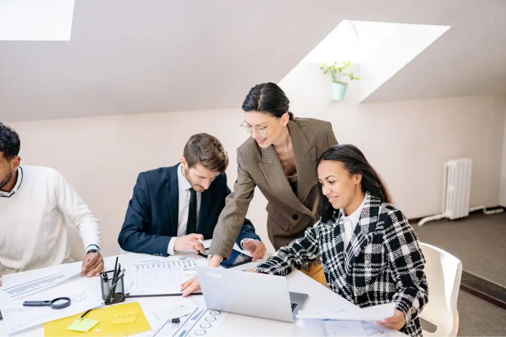 Trois professionnels analysent des données chiffrées sur des documents pour leur cycle de vente